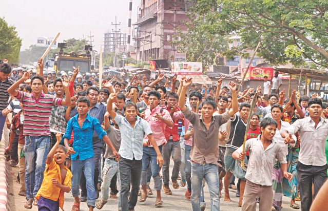 Garment workers demonstrate with sticks in their hands at Genda in Savar area on the outskirts of the capital yesterday demanding trial of those responsible for the death of labourers in Rana Plaza building collapse in the area on Wednesday. Photo: Star