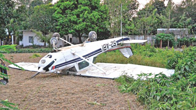 The upturned two-seater Cessna 152 of Bangladesh Flying Academy which crash landed in Shah Makhdum Airport of Rajshahi yesterday. The flight instructor and trainee pilot inside escaped with minor injuries. Photo: Star