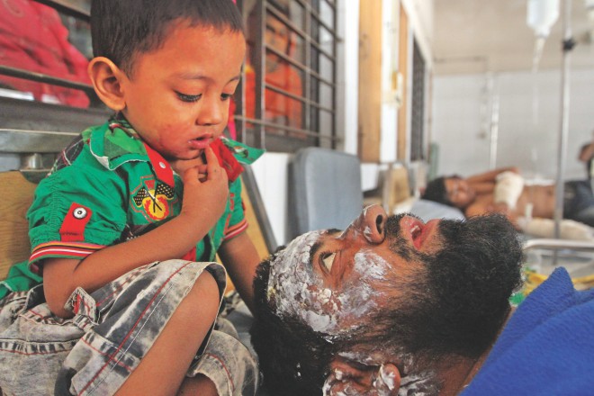Three-and-a-half-year-old Gias and his father Mannan at the burn unit of DMCH. Mannan was badly burnt at Jatrabari in the capital during the 84-hour hartal on November 12 when pickets torched the bus he was in. file Photo: Palash Khan