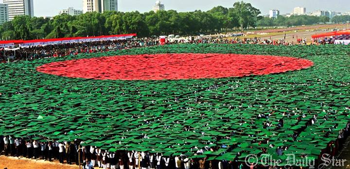 A total of 27,117 volunteers, mostly students, reproduce an emblem of the national flag by standing up with red and green paper blocks in their hands in special formations at the National Parade Ground in Sher-e-Bangla Nagar in the capital. Bangladesh celebrates the 43rd Victory Day  paying rich tributes to the three million martyrs for their supreme sacrifice for the country and with a renewed call for executing all the verdicts against war criminals. 