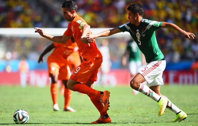 Robin van Persie of the Netherlands controls the ball against Diego Reyes of Mexico during the 2014 FIFA World Cup Brazil Round of 16 match between Netherlands and Mexico at Castelao on June 29, 2014 in Fortaleza, Brazil. Photo: Getty Images