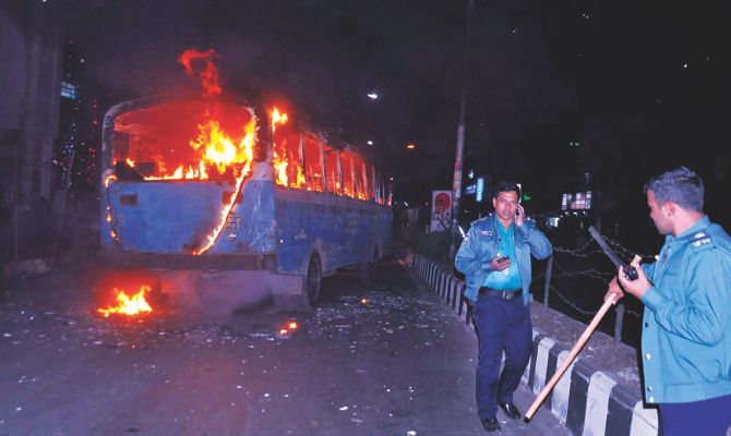 A bus burns on the street in front of Baitul Mukarram mosque in the capital yesterday evening. Alleged supporters of the 20-party blockade had torched the bus. Photo: Banglar Chokh