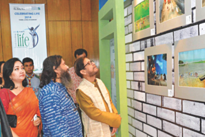 After the inauguration of the programme, the guests along with the host looking at the photo entries of the contest.   Photo: Rashed Shumon And Amran Hossain