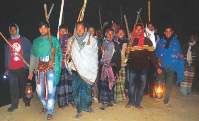 Members of a neighbourhood watch patrol Khatriapara of Sundarganj upazila in Gaibandha late Saturday night. The villagers set up the watch following attacks on Hindus across the country before and after the elections.   Photo: Star