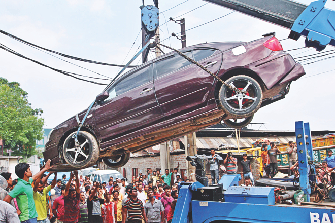 Police seize a car that belongs to the family of Nur Hossain, the prime suspect in the murder of Narayanganj city panel mayor Nazrul Islam and six others, from the compound of a glass factory in Shimrail of Narayanganj. The factory belongs to the in-laws of Awami League lawmaker Shamim Osman. Photo: Anisur Rahman