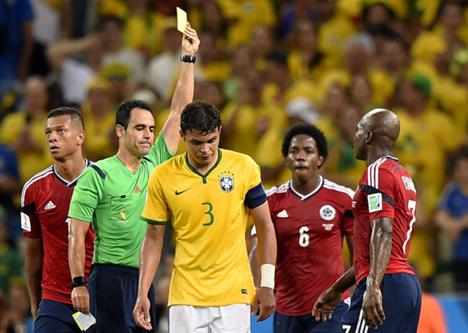 Brazil's defender and captain Thiago Silva (C) receives a yellow card from Spanish referee Carlos Velasco Carballo (2L) during the quarterfinal match between Brazil and Colombia at the Castelao Stadium during World Cup 2014 on July 4, 2014. Photo: AFP/Getty Images