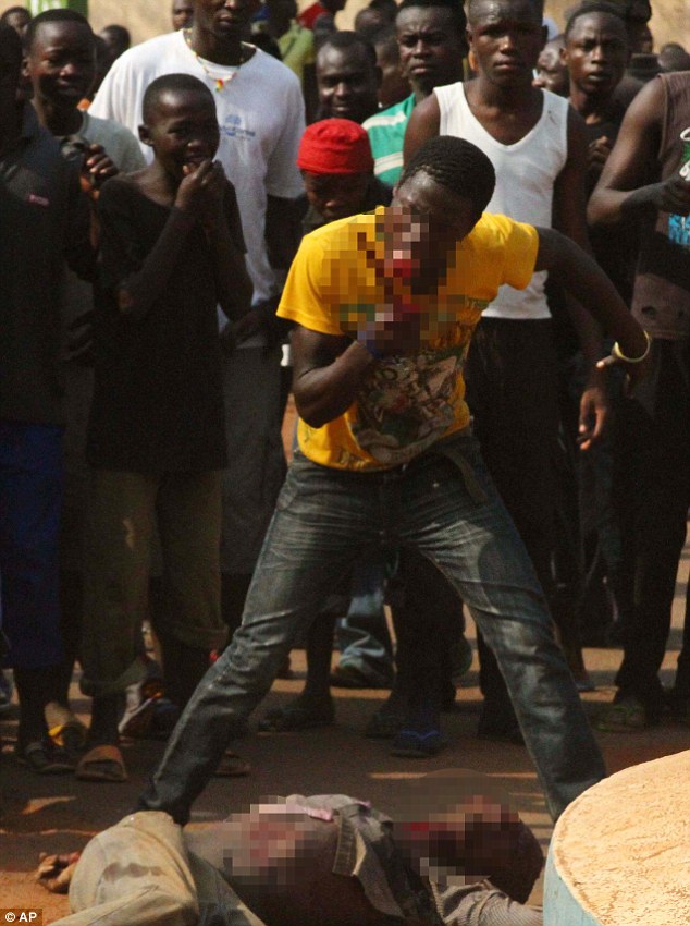 'Mad Dog' licks blood off a knife, as a crowd prepares to burn the body of a lynched Muslim man in Bangui. Photo: AP