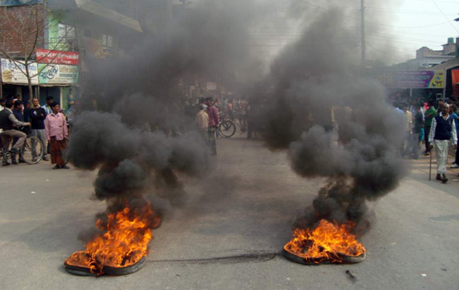 Protesters block Dianjpur-Dhaka highway by burning tyres in Nimtola area under Phulbari municipality on Wednesday. Photo: Star