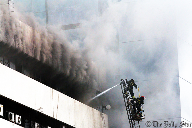Fire fighters spray water from a ladder to douse the fire originated on the top floor of Bangladesh Steel and Engineering Corporation (BSEC) building at Kawran Bazar in Dhaka on Friday. Photo: Polash Khan
