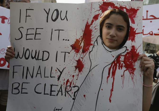An activist holds a banner during a march against domestic violence against women, marking International Women's Day in Beirut March 8, 2014. Photo: Reuters