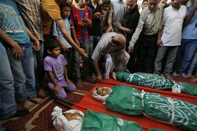 Palestinian mourners gather around the bodies of three siblings of the Abu Musallam family, during their funeral in Beit Lahiya, northern Gaza Strip, Friday. Photo: AP