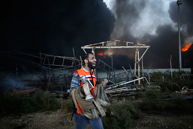 A Palestinian firefighter reacts as he tries to put out a fire at Gaza's main power plant, which witnesses said was hit in Israeli shelling, in the central Gaza Strip July 29, 2014. Photo: Reuters