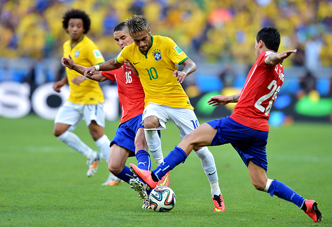 Neymar of Brazil is challenged by Felipe Gutierrez (L) and Charles Aranguiz of Chile during the 2014 FIFA World Cup Brazil round of 16 match between Brazil and Chile at Estadio Mineirao on June 28, 2014 in Belo Horizonte, Brazil. Photo: Getty Images