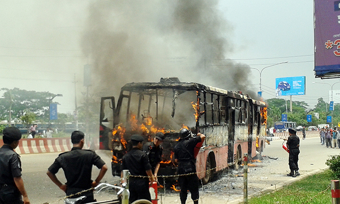 Fire fighters are trying to put off the blaze that broke out at an articulated bus of state-run Bangladesh Road Transport Corporation (BRTC) due to engine explosion on the Airport Road near Hazrat Shahjalal International Airport in Dhaka on August 21, 2014. Photo: Zakir Hossain